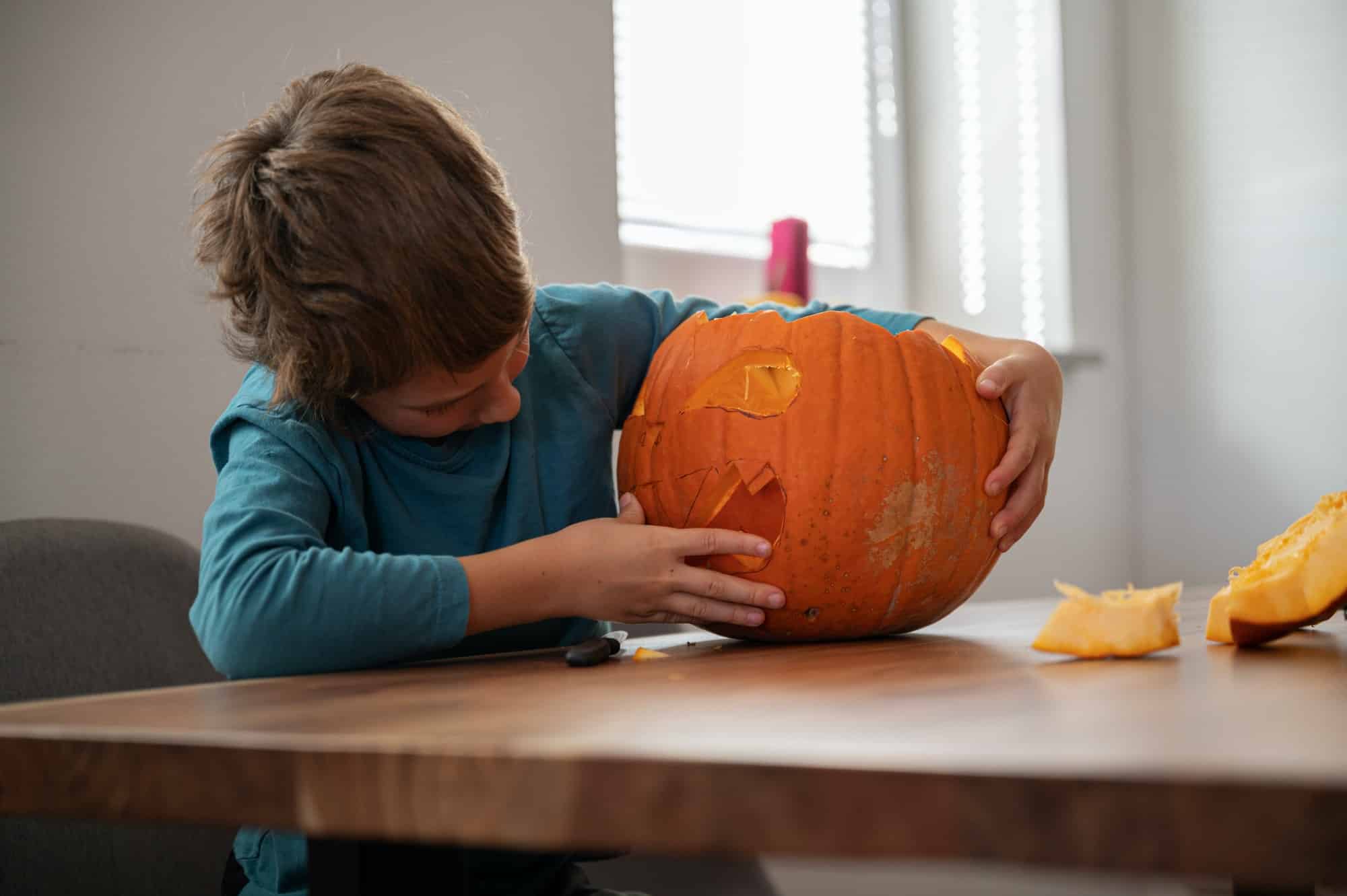 Schoolboy making his own halloween pumpkin