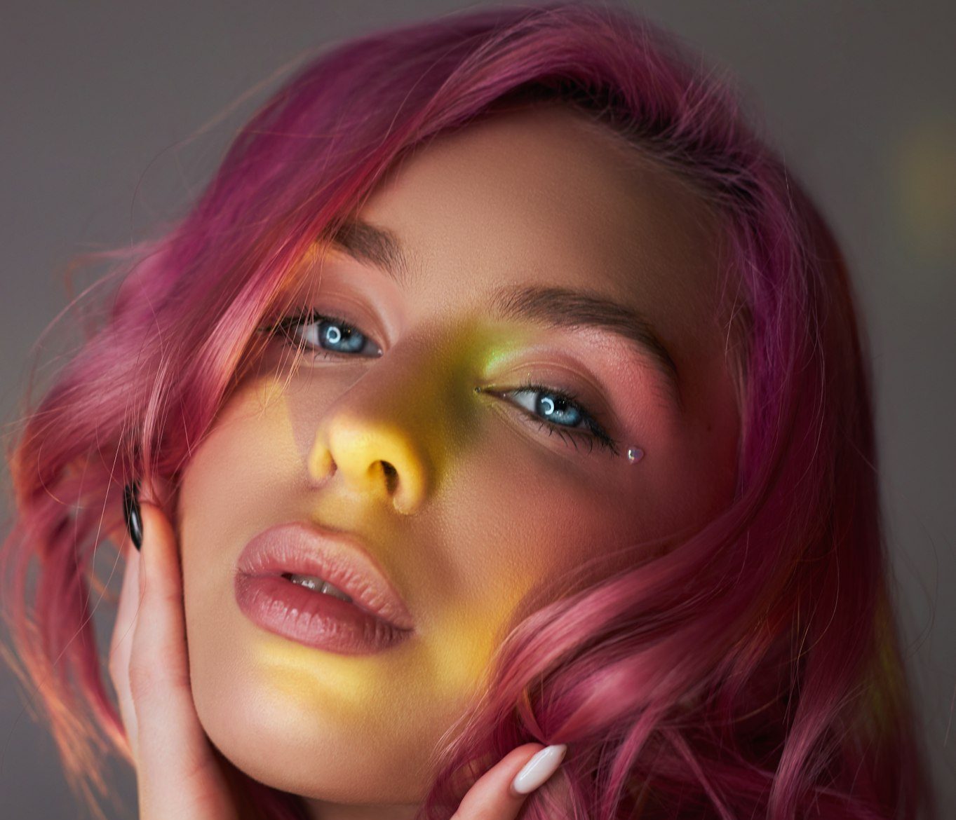 Beauty portrait woman with pink hair, creative vivid coloring. Bright colored highlights and shadows