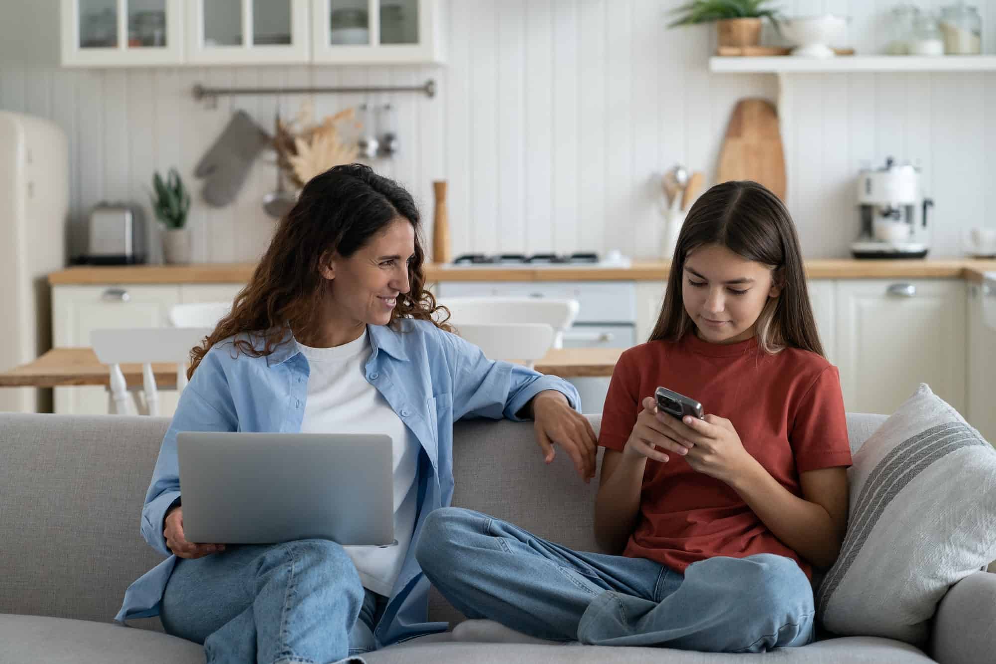 Young smiling modern mother talking to child daughter about online safety